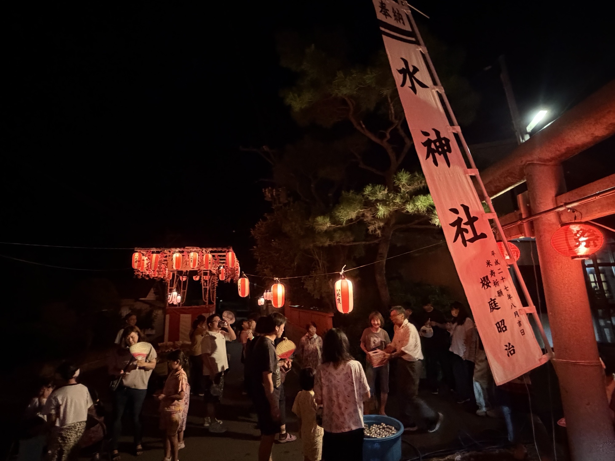 水神社の鳥居前でにぎわう盆踊り会場の様子